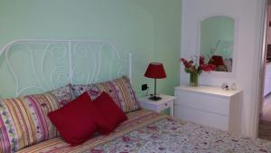 Schlafzimmer mit einem Bett mit roten Kissen und einem Spiegel in der Unterkunft Il Nido in Gravedona