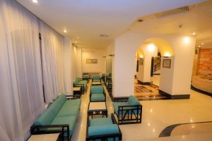a waiting room with green chairs and tables in a hospital at Cleopatra Hotel in Aswan