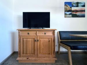 a television on top of a wooden cabinet in a room at Sonnenhof Seeg 12 in Seeg