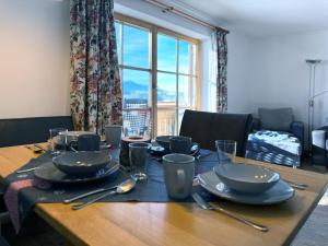 a wooden table with plates and utensils on it at Sonnenhof Seeg 12 in Seeg