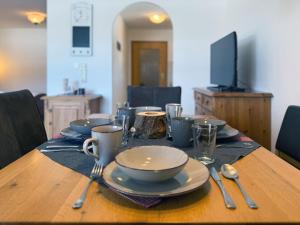 a table with plates and cups and utensils on it at Sonnenhof Seeg 12 in Seeg