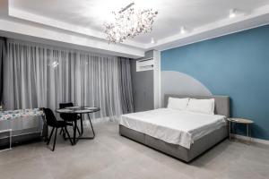 a bedroom with a bed and a table and a chandelier at Velora Apartments in Năvodari