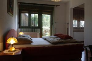 a bedroom with a bed and a lamp on a table at House Drakulić in Korenica