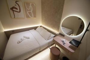a small room with a bed and a mirror at DeLuma-Lebuh Acheh in George Town