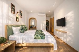 a bedroom with a large bed and a flat screen tv at Casa Del Mar Hotel & Apartment - Sunset Town, Phu Quoc in Phú Quốc