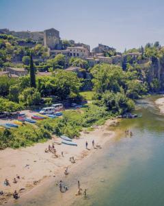 a group of people on a beach next to a river at Camping Le Boem in Balazuc
