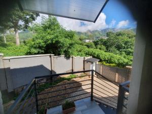 a balcony with a view of a fence and trees at Villa Moni in Zomba