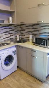 a kitchen with a microwave and a washing machine at Apartment on Tabukashvili Street in Tbilisi City