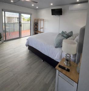 a bedroom with a bed and a table with a lamp at Private guest house Gold Coast - sleeps max 4 in Gold Coast