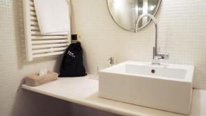 a white bathroom with a sink and a mirror at Locanda Al Cappello in Udine