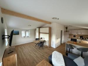 a living room with a table and a kitchen at Ferienwohnung Theus in Albersdorf