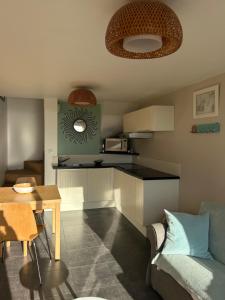 a kitchen with a couch and a table in a room at Villa Denise Petit Gîte in Barneville-Carteret