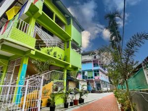 a colorful building on a street with a palm tree at Juihal Residency & Kitchen in Kāziranga