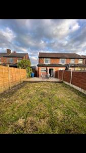 a yard with a fence and a house at The house with a view in Warrington