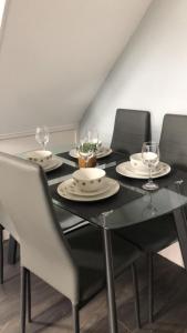a black table with chairs and wine glasses on it at The house with a view in Warrington