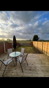 a patio with a table and two chairs and an umbrella at The house with a view in Warrington +3 photos