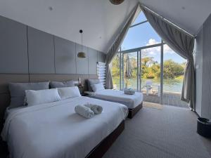 two beds in a room with a large window at M & R 2 float house in Muang Fuang +12 photos