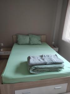 a bed with a blanket on top of it at Етаж от къща - Нощувки Ками in Pleven