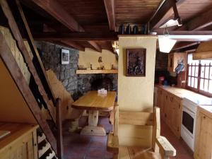 a kitchen with a wooden table and a stone fireplace at Refuge-style chalet Mountain view in Colmars