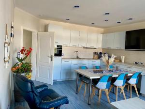a kitchen with a table and blue chairs at Kieferneck Ferienwohnung Hedi in Karlshagen
