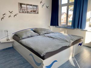 a bed in a bedroom with birds on the wall at Kieferneck Ferienwohnung Hedi in Karlshagen
