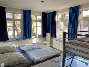 a bedroom with blue curtains and a bunk bed at Kieferneck Ferienwohnung Hedi in Karlshagen