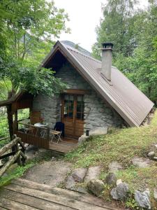a stone cabin with a porch and a wooden deck at Refuge-style chalet Mountain view in Colmars