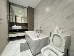 a white bathroom with a toilet and a sink at Fynn Bangkok Asoke Condo in Bangkok +39 photos