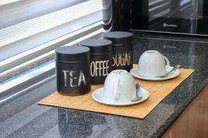 two coffee cups and saucers on a counter at The Orange Corner III in Johannesburg +3 photos