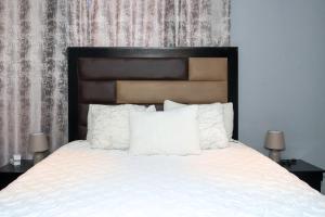 a bedroom with a bed with white sheets and pillows at The Orange Corner III in Johannesburg