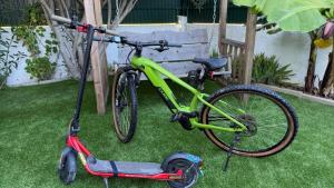 a bike parked on the grass next to a scooter at CHESA RUISA in Castro Marim