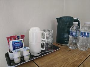a coffee maker on a tray with cups and water bottles at Littledean House Hotel in Cinderford