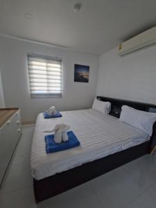 a bedroom with a large bed with towels on it at The nice condo 2 BR at Karon in Karon Beach +22 photos