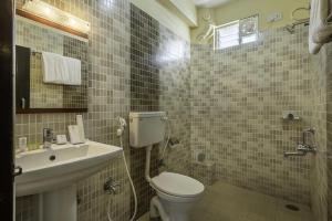 a bathroom with a toilet and a sink at Daffodil Suites, Manyata Tech Park, Bengaluru in Bangalore