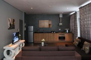 a living room with a couch and a kitchen at The Orange Corner III in Johannesburg