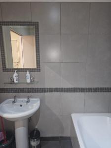 a bathroom with a sink and a mirror and a tub at The Orange Corner III in Johannesburg