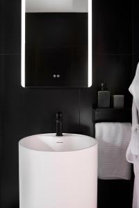 a bathroom with a white sink and a mirror at Appartement Cinéma Ecran géant & Dolby Atmos in Niort +7 photos