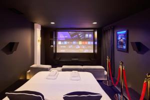 a room with a table and a tv in a room at Appartement Cinéma Ecran géant & Dolby Atmos in Niort