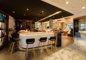 a restaurant with a bar with stools at Holiday Inn Stuttgart by IHG in Stuttgart