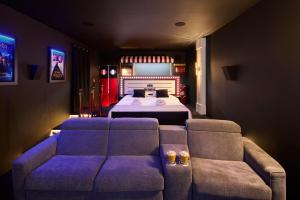a bedroom with a couch and a bed in a room at Appartement Cinéma Ecran géant & Dolby Atmos in Niort