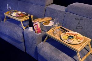 two tables with plates of food and a bottle of wine at Appartement Cinéma Ecran géant & Dolby Atmos in Niort