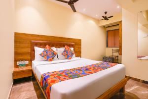a bedroom with a large bed in a room at FabHotel Samrath in Mumbai