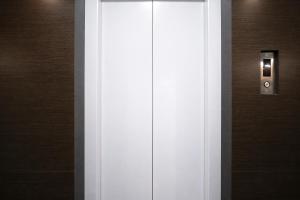 a white door with a lightswitch on a wall at FabHotel Samrath in Mumbai