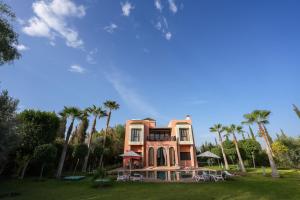 a large house with palm trees in front of it at Janat Al Atlas Resort & Spa in Marrakesh