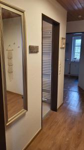 a hallway with a mirror and a door to a room at lüttje Meerzeithuus in Carolinensiel