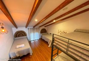 a room with two beds and a bench in it at Casa Rural El Junquillo in Cuevas de San Marcos +37 photos
