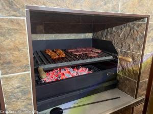a grill with meat and other food on it at Casa Rural El Junquillo in Cuevas de San Marcos