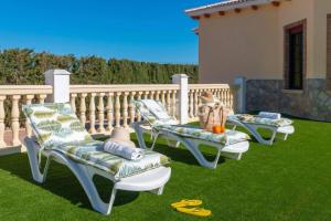 three chairs sitting on the grass in a yard at Casa Rural El Junquillo in Cuevas de San Marcos