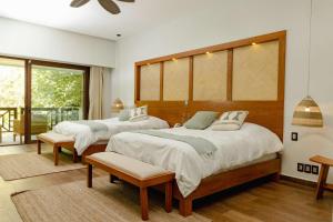 a bedroom with two beds and a balcony at Soul Spring Sanctuary Cuernavaca, WorldHotels Luxury in Xochitepec +85 photos