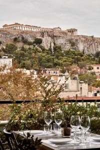 a table with wine glasses sitting on top of a hill at The Zillers Boutique Hotel in Athens